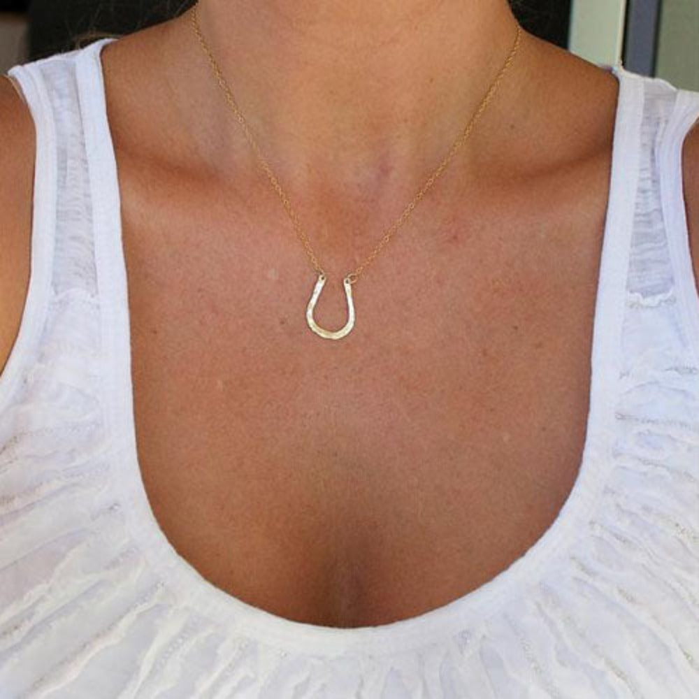 Teressa Lane Jewelry delicate gold horseshoe necklace worn with a white sleeveless top