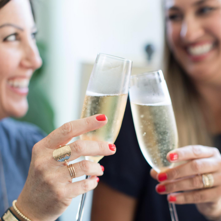 Two women toasting with champagne wearing Katie Ring for women by Teressa Lane Jewelry