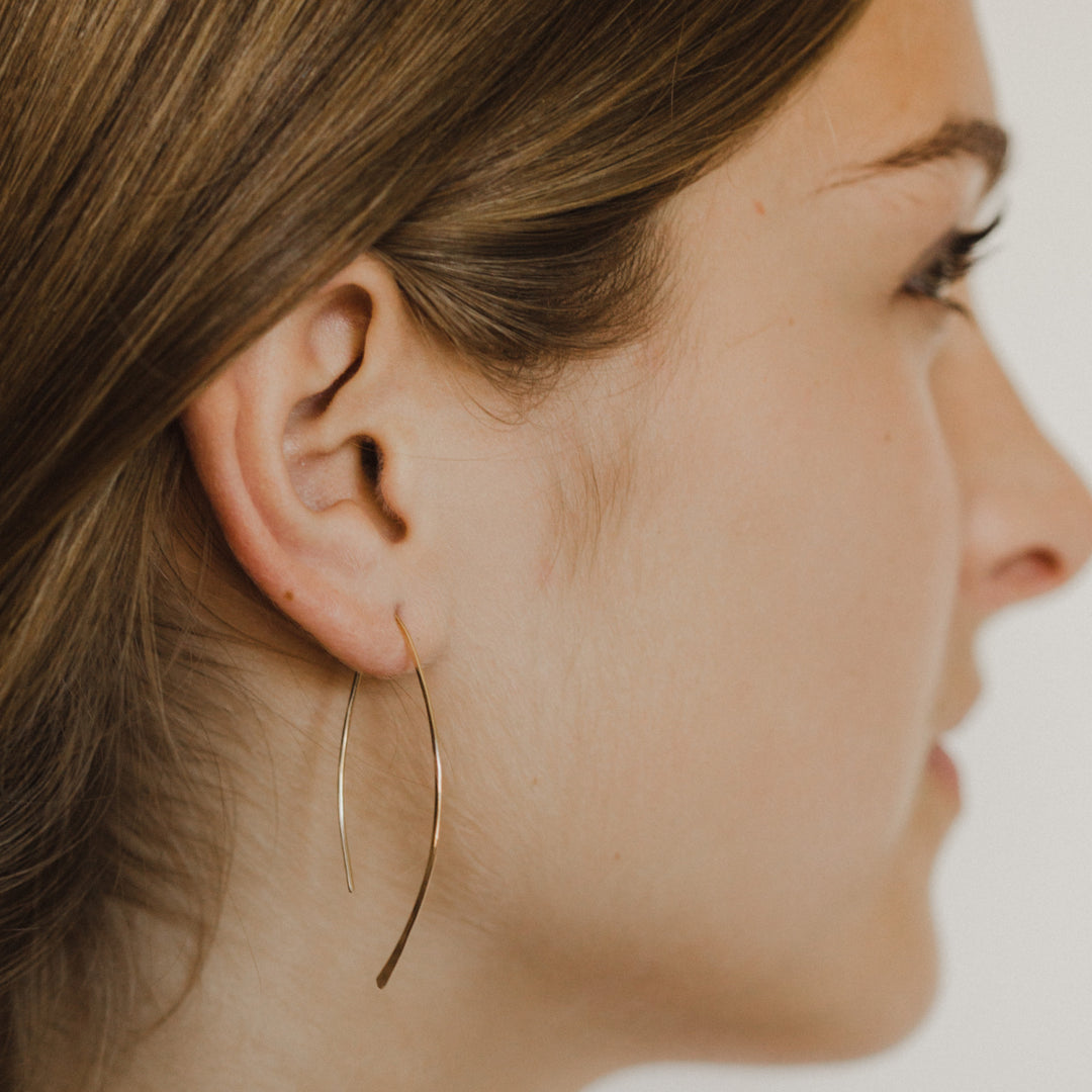 Teressa Lane Jewelry delicate gold leaf threader earrings worn on woman’s ear